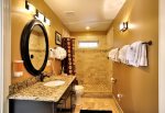 Jack and Jill bathroom with large tumbled marble shower with Tommy Bahama amenities